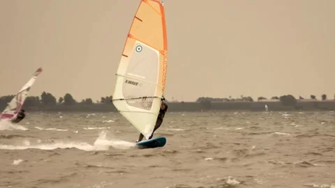 Surfer with orange sail in strong wind Video stock 254469799