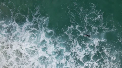 Surfer paddling on the board through waves deep ocean surfing beach 動画素材 196674831