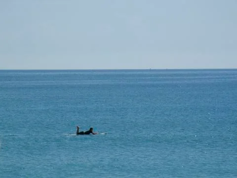 Surfer paddling in ocean Stock Photos