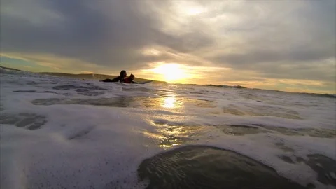 Surfer paddling out to catch a wave with his young daughter. 스톡 동영상 88368854