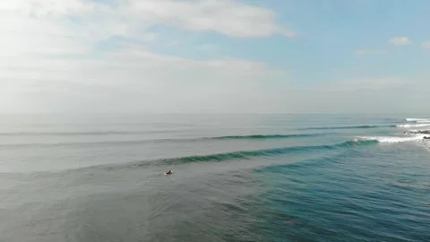 Surfer Paddling Towards a Wave in the Open Ocean, Aerial View Stock Footage 303521449