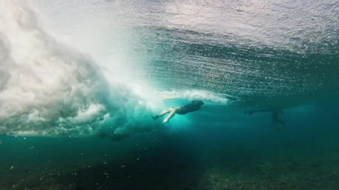 Surfer passes under the ocean wave. Person surfs the wave in the Maldives and 스톡 동영상 321101341
