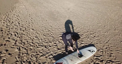 Surfer prepares to go down into the water and runs with a board to the ocean Stock Footage 130168567