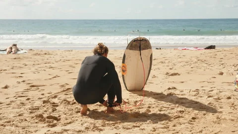 Surfer prepares to hit the waves at a sunny beach with surfboard Stock Footage 321564981