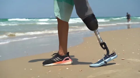 Surfer with prosthesis walking towards the ocean Video stock 142618559