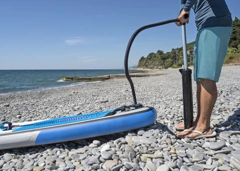 Surfer pumping up SUP 스톡 사진