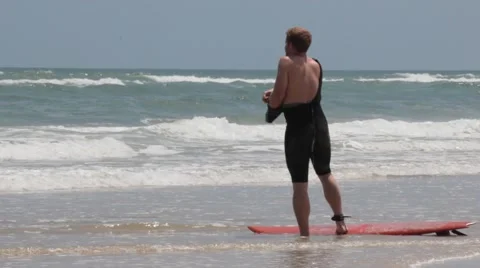 Surfer Puts on Wet Suit Stock Footage 40516754