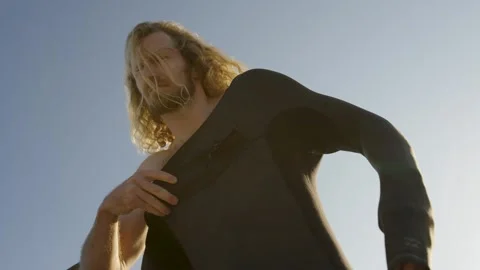 Surfer putting on his wetsuit to go for a surf Stock Footage 340219569