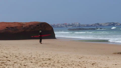 Surfer with Red Surfboard by Cliff Looking at Ocean Stock Footage 344948081