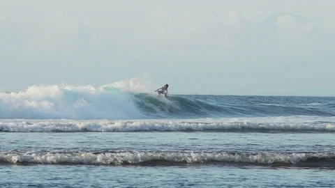 Surfer rides blue ocean wave in Bali Indonesia in slow motion 스톡 동영상 83716301