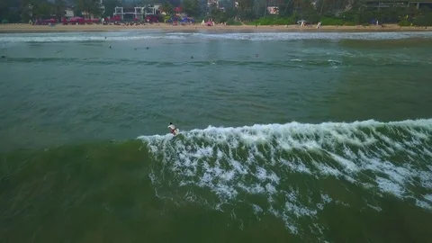 Surfer rides blue ocean wave at sunset drone footage Stock Footage 84999662