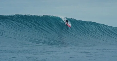Surfer rides giant blue ocean wave. Shot on RED in 4k. Big wave surfing. Slow mo Stock Footage 79743770