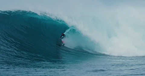 Surfer rides giant blue ocean wave. Shot on RED in 4k. Big wave surfing. Slow mo Stock Footage 79744600