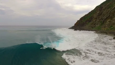 A surfer rides a giant wave. About nature, dominate nature, sports, risk Stock Footage 71597801
