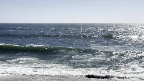 Surfer rides the ocean waves under clear skies. The scene captures action, .. Vidéo 318166978