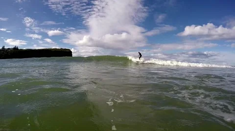 Surfer rides wave and walks to the nose of his long board. Slow motion 120fps. Video stock 64357906