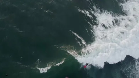 Surfer rides a wave on his orange board || aerial shot Stock Footage 237680585