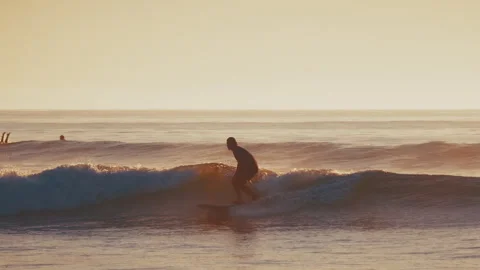 Surfer rides the wave in the ocean during calm sunrise. The Kuril islands, 库存影片 330535556