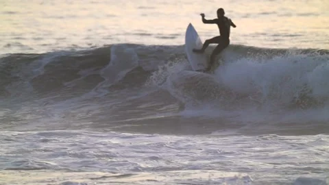 Surfer rides the wave over the top slow motion Stock Footage 146567693