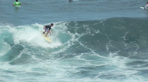 A surfer rides a wave in the surf at the ocean blue in the surf spot. Stock Footage 61204903