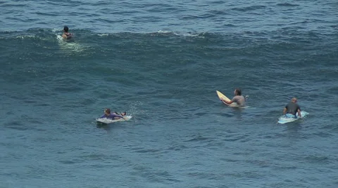 A surfer rides a wave in the surf at the ocean blue in the surf spot. Stock Footage 61204945