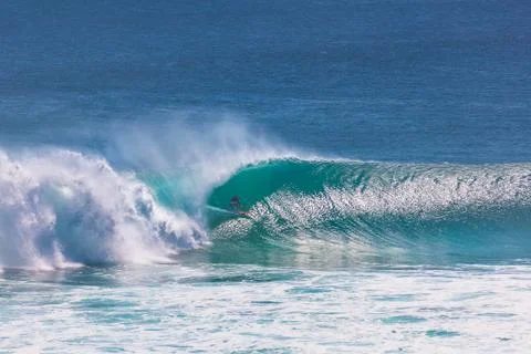 Surfer riding into barrel section of big green wave at Uluwatu, Bali, Indonesia Stock Photos