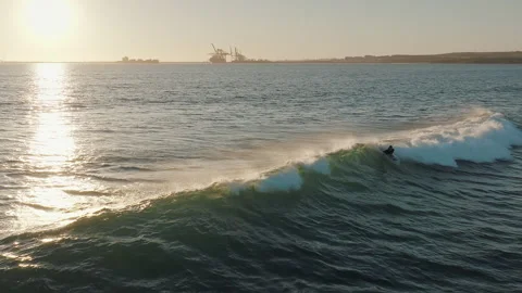 Surfer riding big blue ocean wave at golden sunset. Stock Footage 285736846