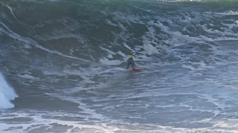 Surfer is riding big wave he is accompanied by a jet ski nearby. Extremal big Stock Footage 302565029