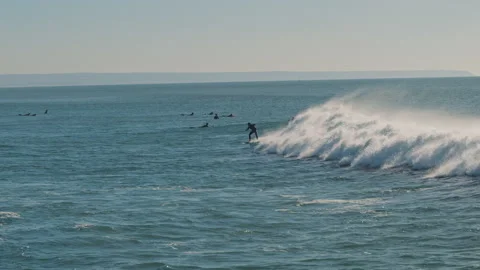 Surfer riding blue Atlantic Ocean waves on a beautiful sunny day. Stock Footage 130627119