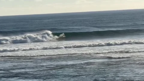 Surfer Riding Large Barrel Wave on Sunny Coastline Stock Footage 339584096