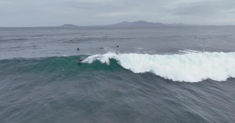 Surfer riding a wave on a cloudy day Stock Footage 345422363