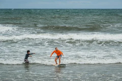 Surfer Riding a Wave During a Lesson with an Instructor Stock-Fotos
