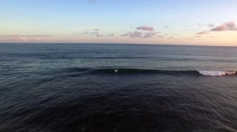 Surfer riding a wave in the sunset Stock Footage 61949276
