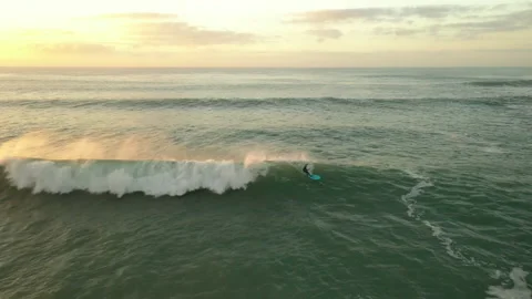 Surfer riding wave at sunset Vídeo Stock 169450000