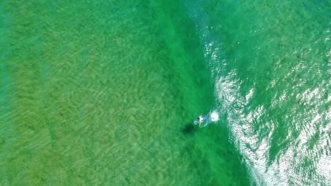 Surfer Riding Waves Above Vibrant Blue Water Stock Footage 331623532
