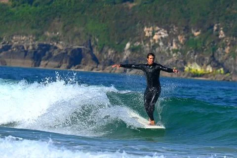 Surfer riding waves along dramatic coastline (3), 27/08/2025 Stock-Fotos