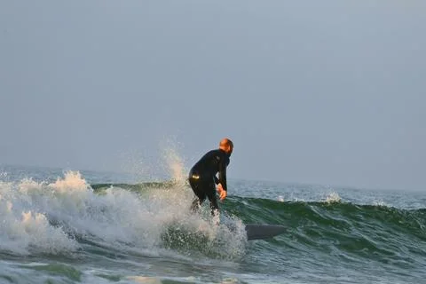 Surfer riding waves along dramatic coastline (2) , 27/08/2025 Stock Photos