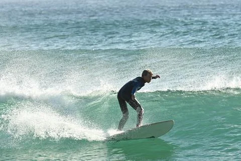 Surfer riding waves along dramatic coastline (10) , 27/08/2025 Stock Photos