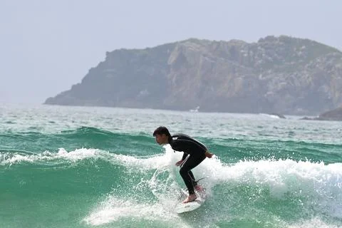 Surfer riding waves along dramatic coastline (4), 27/08/2025 Stock Photos