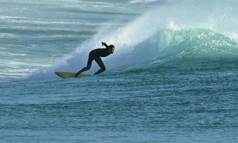 Surfer riding waves along dramatic coastline (14) ,27/08/2025 Stock Photos