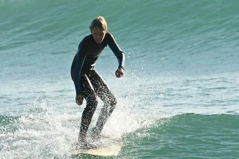 Surfer riding waves along dramatic coastline (12) , 27/08/2025 Stock Photos