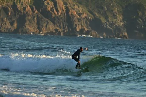 Surfer riding waves along dramatic coastline (17) , 27/08/2025 Stock Photos