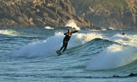 Surfer riding waves along dramatic coastline (18) , 27/08/2025 Stock Photos