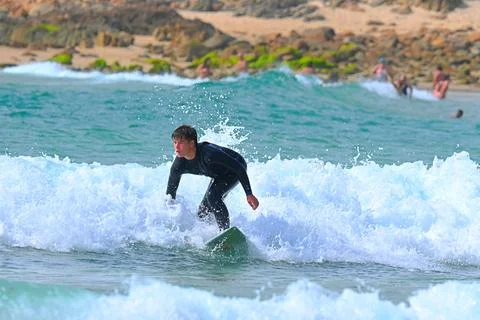 Surfer riding waves along dramatic coastline (19) , 27/08/2025 Stock Photos