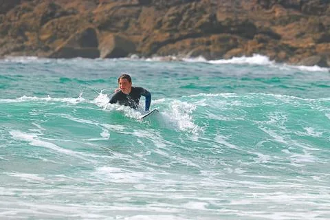 Surfer riding waves along dramatic coastline (21) , 27/08/2025 Stock Photos