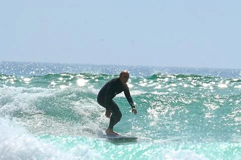 Surfer riding waves along dramatic coastline (23) 27/08/2025 Stock Photos