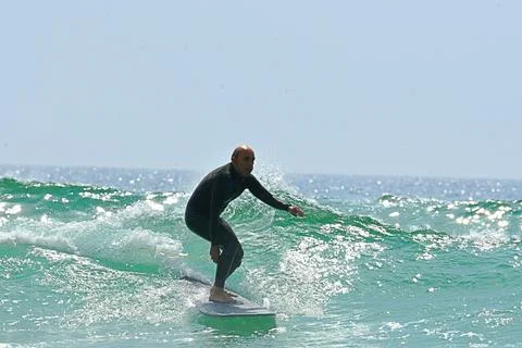 Surfer riding waves along dramatic coastline (24), 27/08/2025 Stock Photos