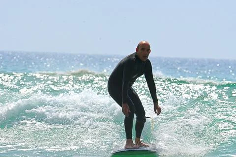 Surfer riding waves along dramatic coastline (25) , 27/08/2025 Stock Photos