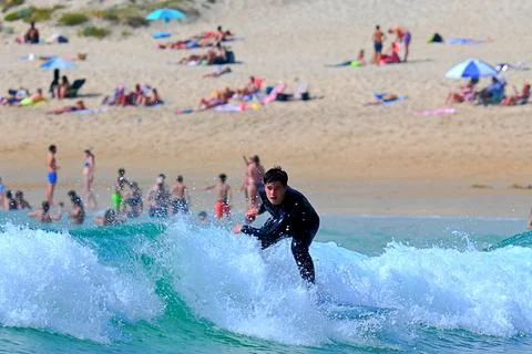 Surfer riding waves along dramatic coastline (27) ,27/08/2025 Stock Photos