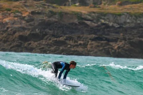 Surfer riding waves along dramatic coastline (30) ,27/08/2025 Stock Photos